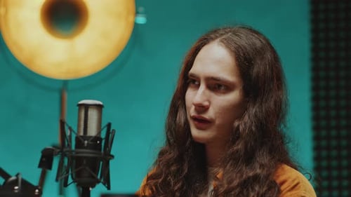 Young Podcast Guest Speaking in Mic as Recording Interview in Studio