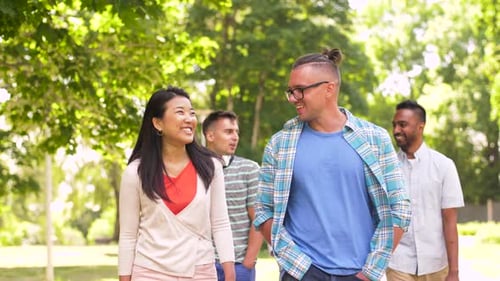 Group of friends walking and talking in park