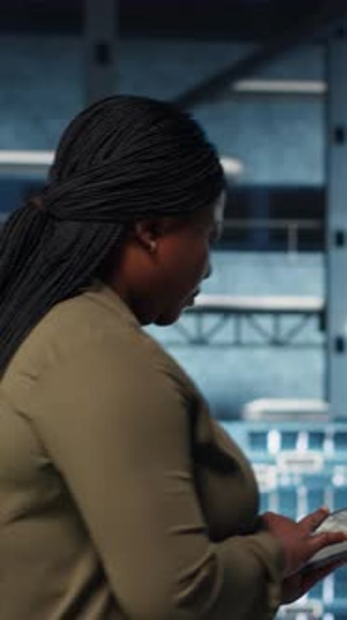 Vertical Video Smiling Data Center Technician Using Tablet to Manage Software Updates