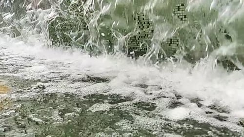 A
água cai de perto ou da fonte para uma pequena piscina na cidade. Câmera lenta