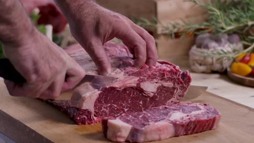 Slicing Raw Ribeye Beef Roast on Cutting Board