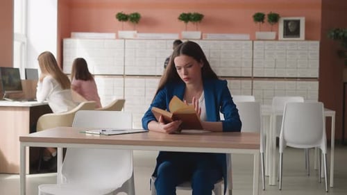 Woman Reads Book in Public Library Hall
