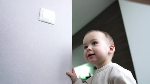 Adorable Infant Interacts With Light Switch at Home
