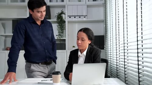 Business Professionals Collaborating at Desk in Modern Office