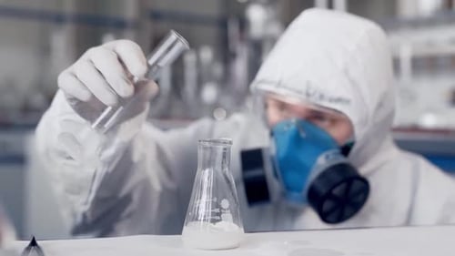 Scientist in Lab Pouring Liquid Into Flask