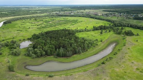 Summer Landscape with Forest Green Meadows and a Village in the Distance Aerial View