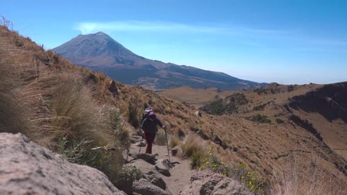 junger männlicher Rucksacktourist, Wanderer mit Trekkingstöcken, genießt die Berge