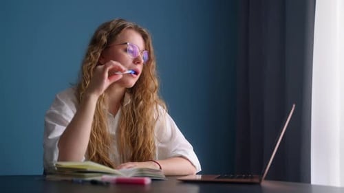 Woman Studying with Laptop and Notebook at Desk