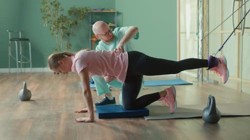 The Personal Trainer Helps the Athlete to Perform Exercises in the Gym