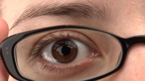 Close-up of a woman's eye, then glasses