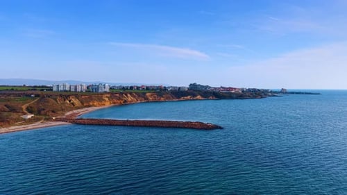 Long pier at the blue waterscape. Revealing view on the cityscape located