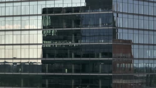 Dynamic Aerial Medium Closeup of Blue Reflective Windows on High-Rise Office Building