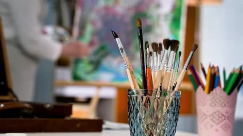 Creative Workshop Art Brushes in Glass Against the Background of System of a Female Artist While