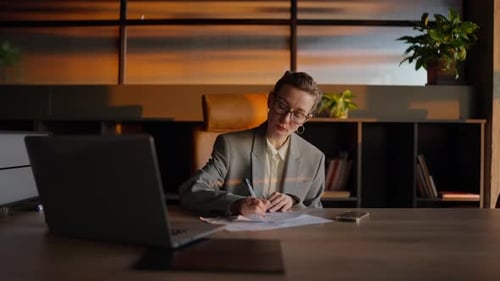 Businesswoman Writing at Office Desk During Daytime