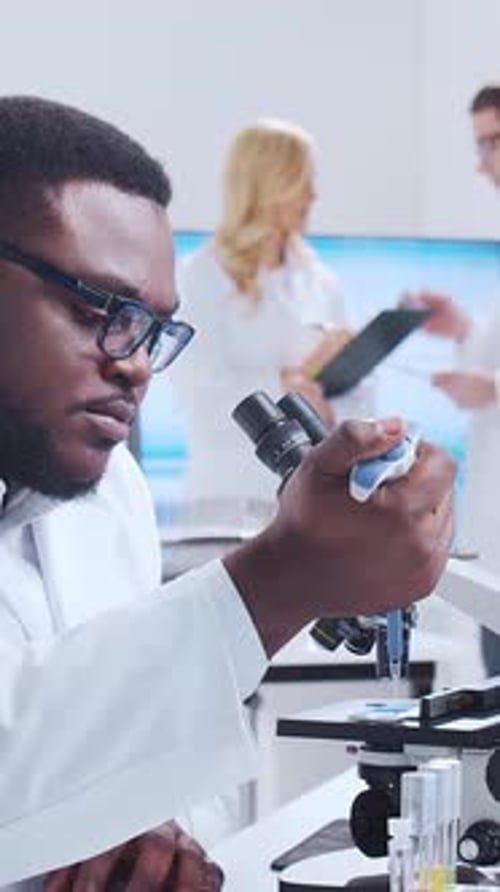 Medical Researcher Using Microscope in a Lab