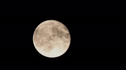 Full Moon with Wispy Clouds Against Black Sky
