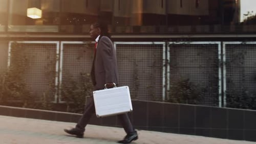Steadicam eines afroamerikanischen Geschäftsmannes bei Sonnenaufgang mit Aktentasche