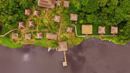 Wooden Ecolodge Nestling Alongside Meandering River Merging Harmoniously with Lush Rainforest and