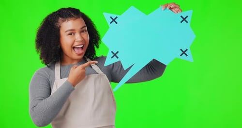Happy woman, speech bubble and pointing on green screen for advertising against a studio background