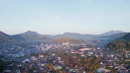 Aerial view of Bajawa town surrounded by mountains at misty sunrise