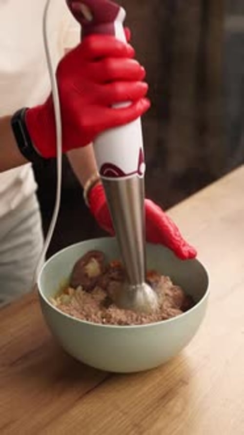 The chef prepares a dish of meat in the kitchen. Close-up