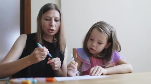 Woman and Child Drawing Together at a Table