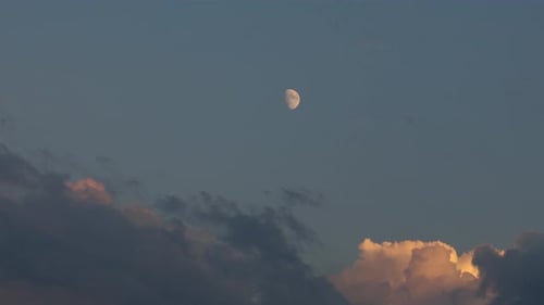 Timelapse de la demi-lune en début de soirée. Il y a encore un peu de soleil qui brille sur les nuages et