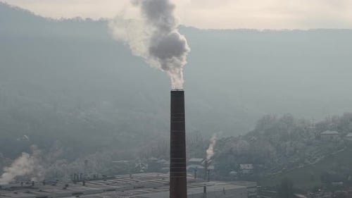 Drone Shot of Toxic Smoke From Chimney Going Into Atmosphere Above Industrial Town