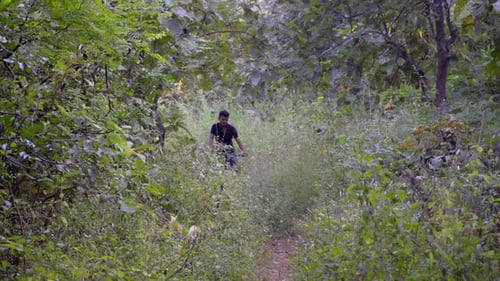 boy man cycling through deep jungle off-road