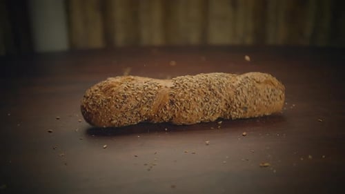 Loaf of Bread Falls onto Wooden Surface