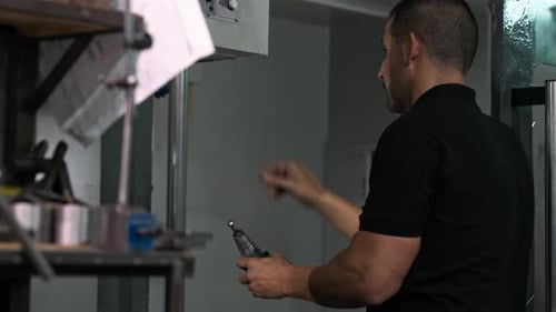 Man Operating Machinery in Industrial Workplace
