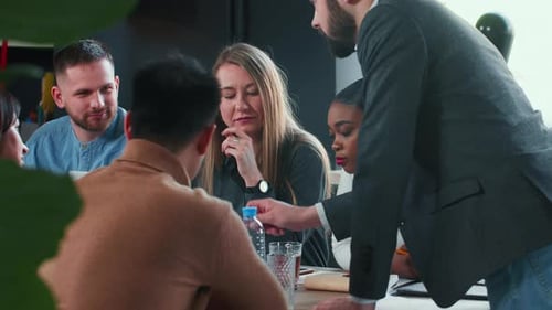 Teamwork Concept Rear View Young Male Boss Leading Multiethnic Team Brainstorming Meeting at Modern