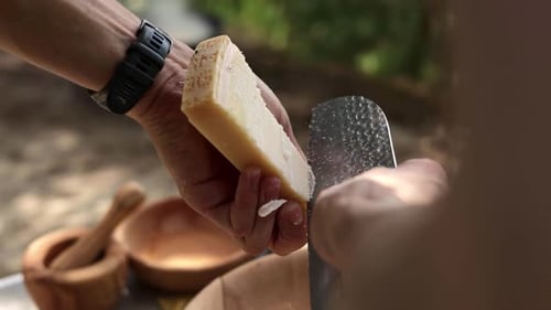 Le chef tranche du fromage à pâte dure avec un couperet