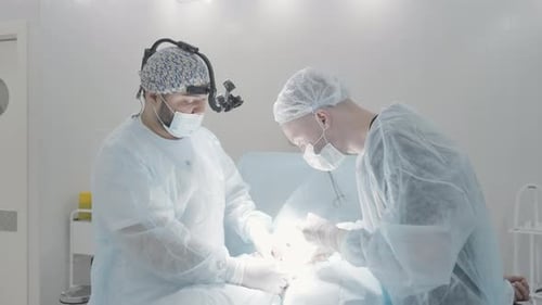 Surgeons Performing Delicate Operation in Bright Operating Room