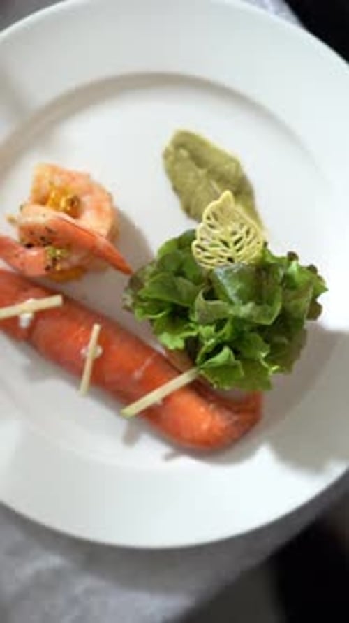 View of plated shrimp dish with colorful peppers, garnished with a yellow sauce, close up shot