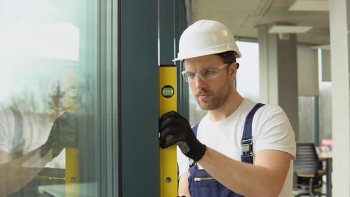 A Repairman in Uniform Installs Pvc Windows in New Office