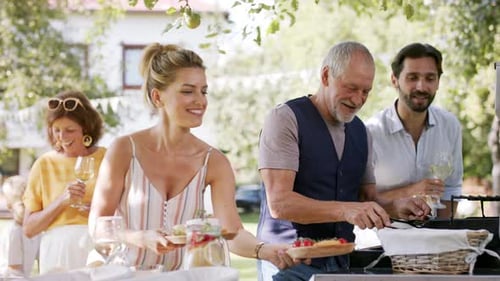 Family Having a Garden Party Father with Son Barbecuing