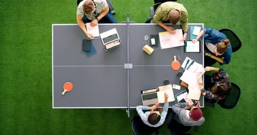Team Collaboration Around Ping Pong Table in Modern Office
