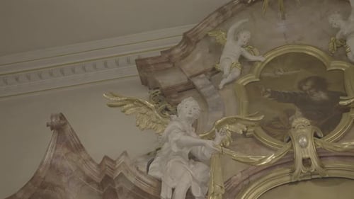 Sculptures of angels with golden wings on a baroque altar in a church, picture of god in the middle