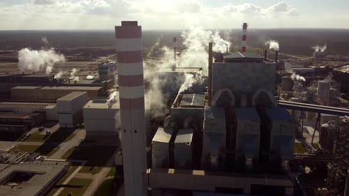 aerial tilt down of smokers chimney factory industrial smog chemical waste pollution