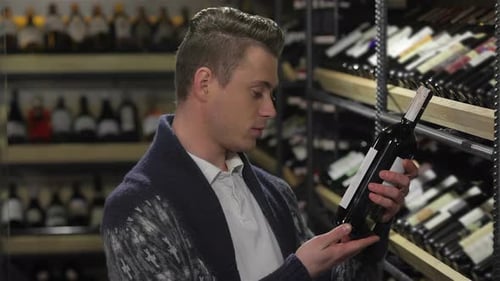 Man in a Supermarket Choosing the Right Wine