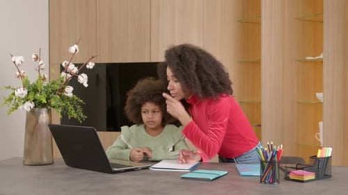 Woman Helps Child with Homework at Home