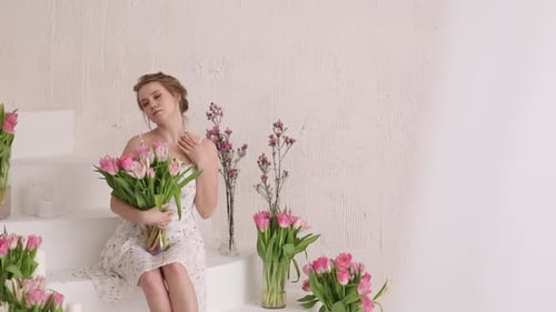 Young Woman Holding Tulips Surrounded by Flowers