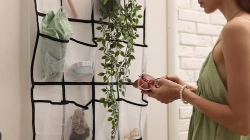 Femme mettant des lunettes dans un étui près de l'organisateur avec différentes choses à l'intérieur, gros plan