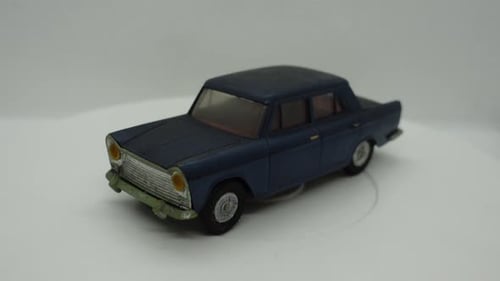 Blue Toy Car Rotating on White Surface