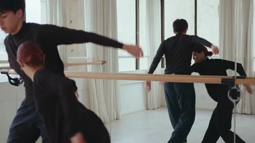 Dancers Practice Ballet Moves in Bright Studio