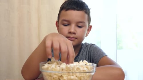 Boy Enjoys Bowl of Delicious Popcorn Snack
