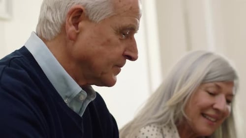 Senior couple and young man conversing indoors