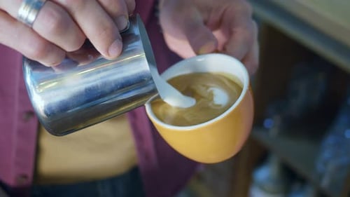 Barista Pouring Steamed Milk to Create Latte Art