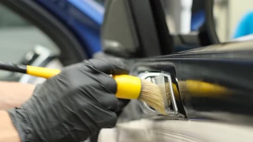Detailer Cleans Car Interior with Brush
